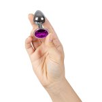 Metalowy korek analny z kryształkiem w dłoni pokazuje kompaktowy rozmiar i eleganckie wykończenie.